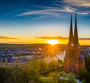 Blick auf die Markuskirche in Chemnitz bei Sonnenuntergang mit zwei markanten Kirchtürmen vor einer malerischen Altstadtkulisse.
