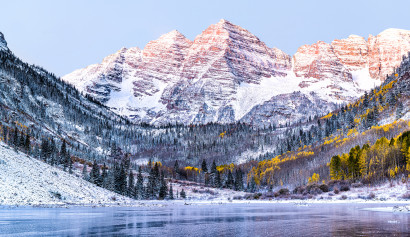 Maroon Bells Morgensonnenaufgang mit Sonnenlicht auf dem Gipfel in Aspen, Colorado Rocky Mountain und herbstlichem gelbem Laub
