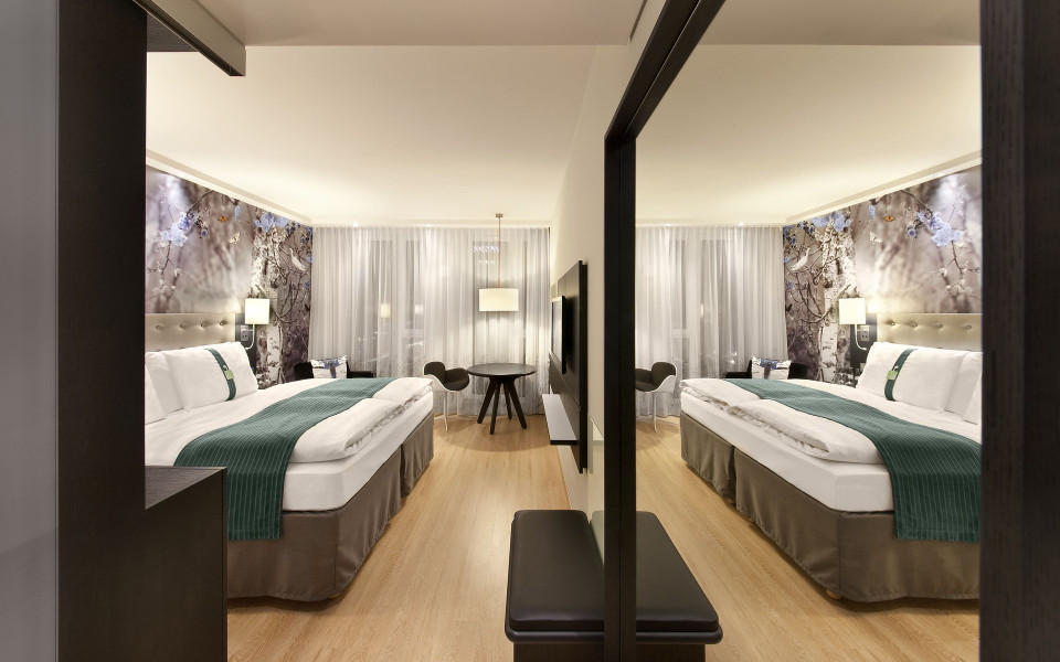 Modernes Hotelzimmer mit großem Spiegel und Bett