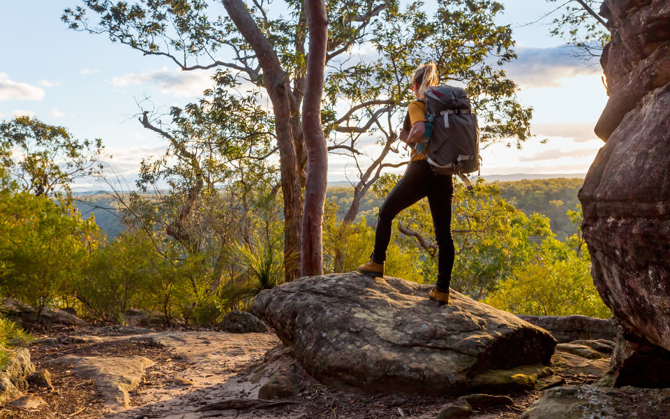 Frau mit Rucksack beim Wandern im australischen Buschland