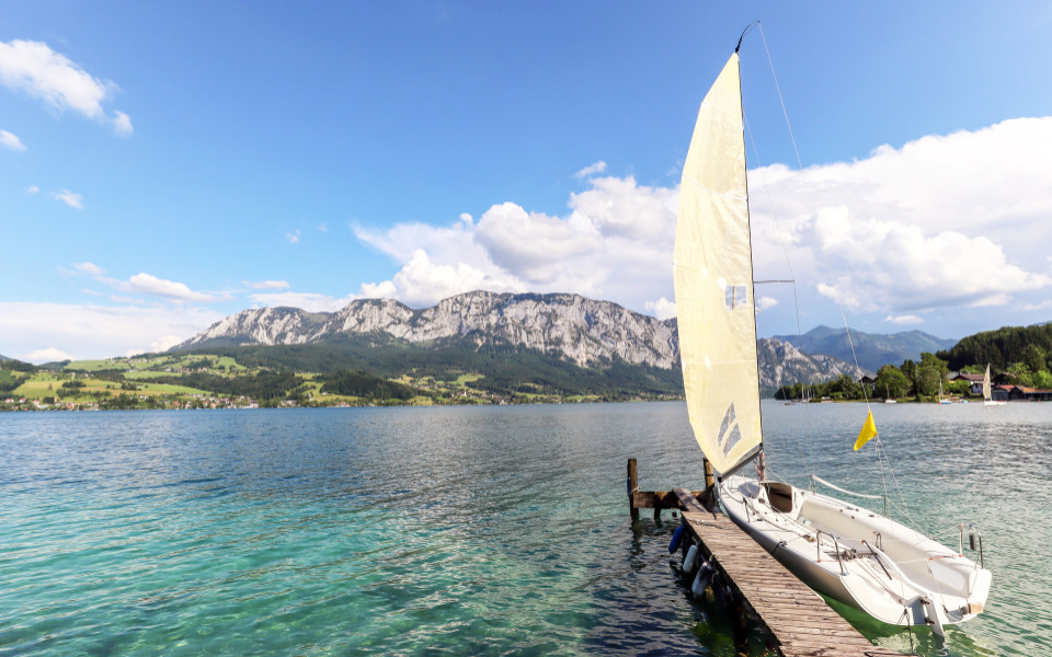 Blick auf Attersee mit Segelboot und Alpen bei Nussdorf, Salzburg Österreich