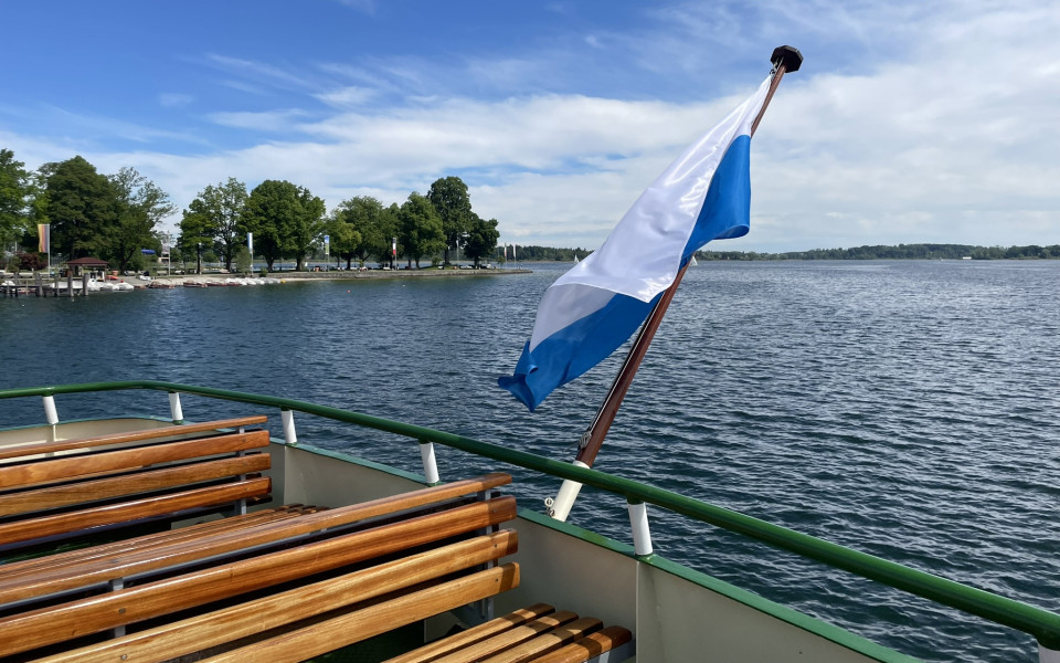 Heck eines Schiffs mit Flagge am Chiemsee