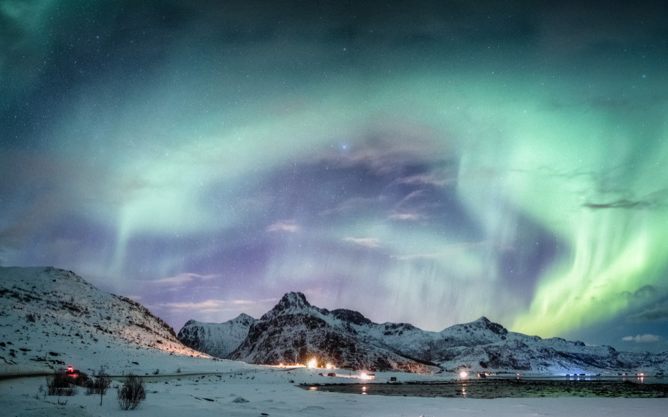 Nordlichtexplosion auf schneebedeckter Bergkette