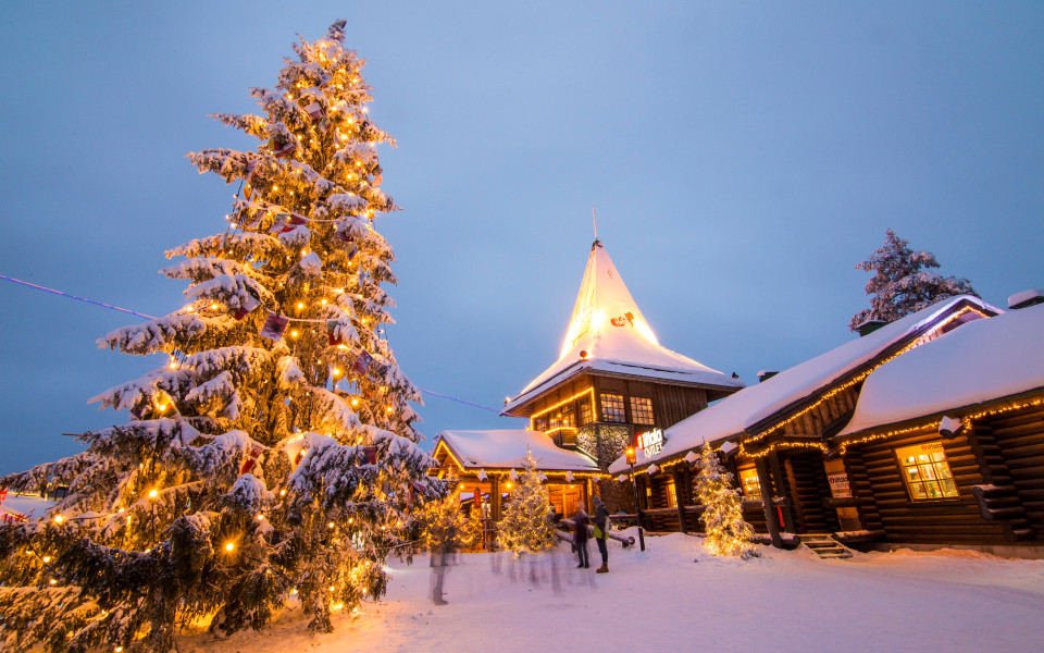 Beleuchtetes Weihnachtsmanndorf in Rovaniemi mit schneebedeckten Häusern